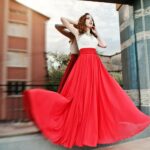 portrait-fashionable-girl-red-evening-dress-posed-background-mirror-window-modern-building-blowing-dress-air_wp-1