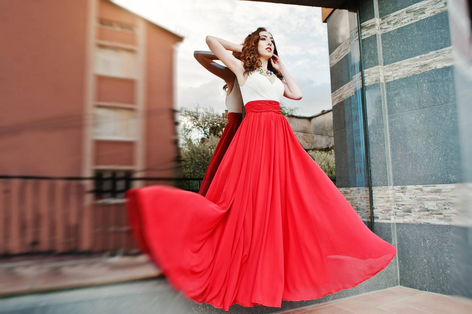 portrait-fashionable-girl-red-evening-dress-posed-background-mirror-window-modern-building-blowing-dress-air_wp-1